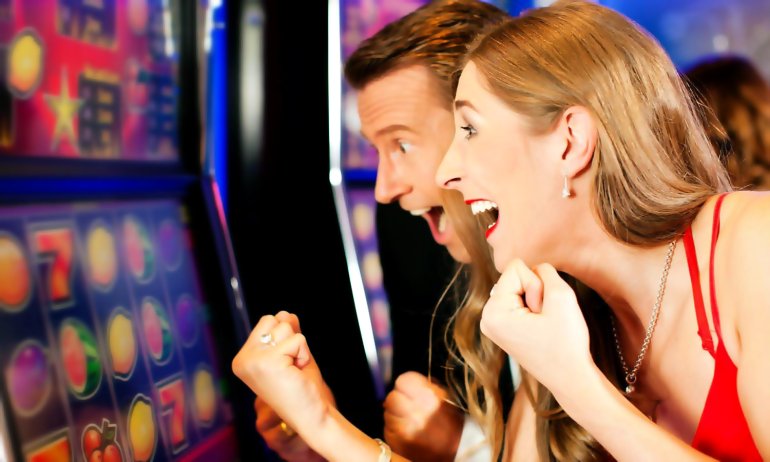 Парень с девушкой у игровых автоматов ощущают удачу и азарт